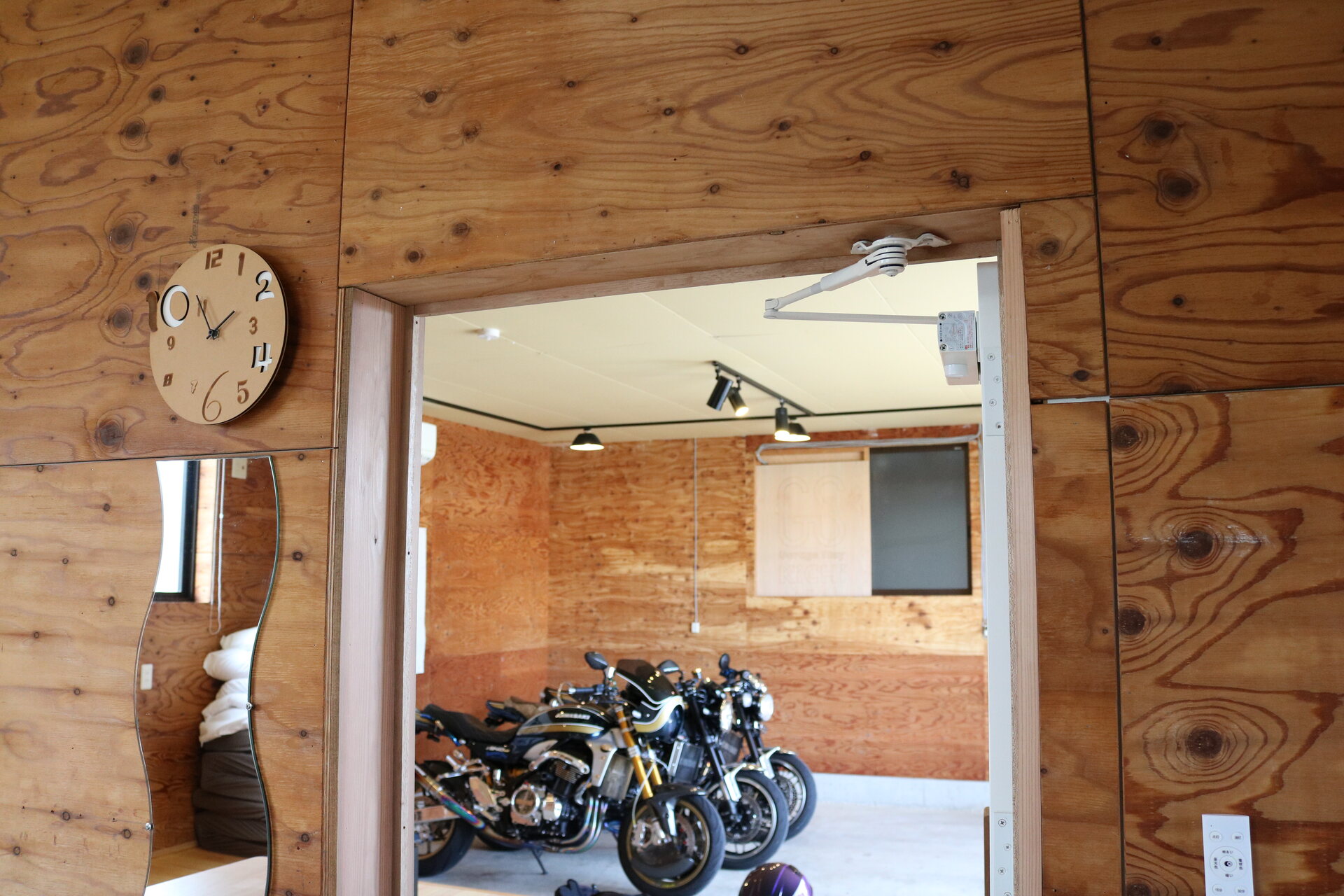 居室の開口越しに、ガレージのバイクが見える